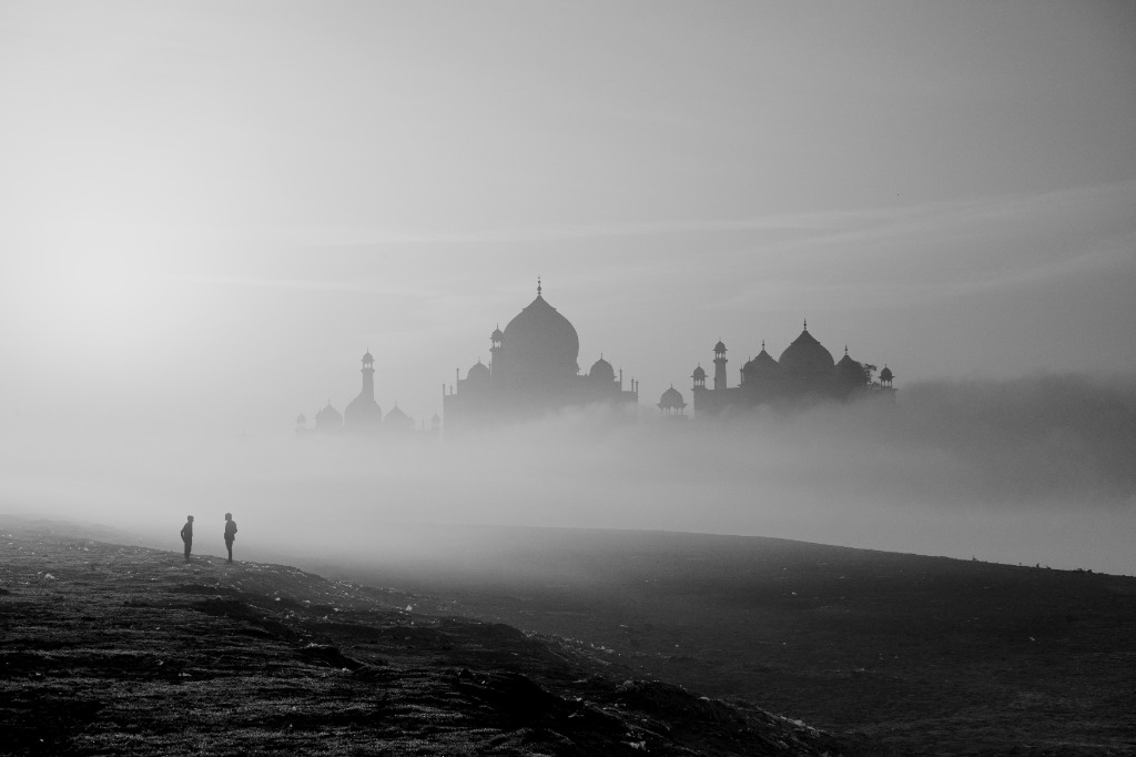 Monochrome study of Taj Mahal emerging through river fog